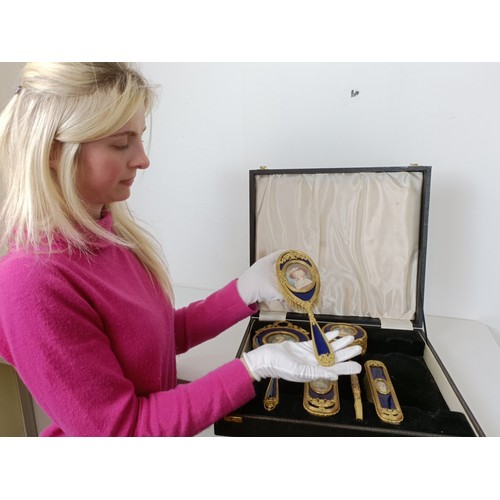 264 - An impressive early 20th century gilt metal and blue enamel dressing table set, inset with portrait ... 