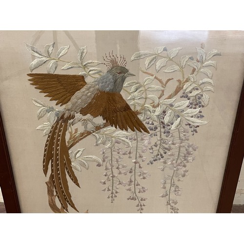 904 - A silk embroidered panel, decorated an exotic bird and blossom, inset in a firescreen with a mahogan... 