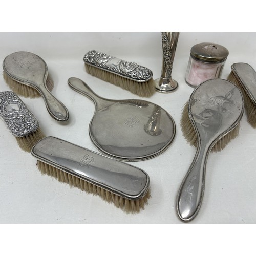 320 - A George V silver posy vase, a silver backed mirror, assorted brushes, and a glass box with a silver... 