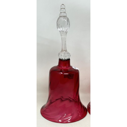 915 - A cranberry and clear glass bell, 34 cm high, and two others, all lacking ringers (3)