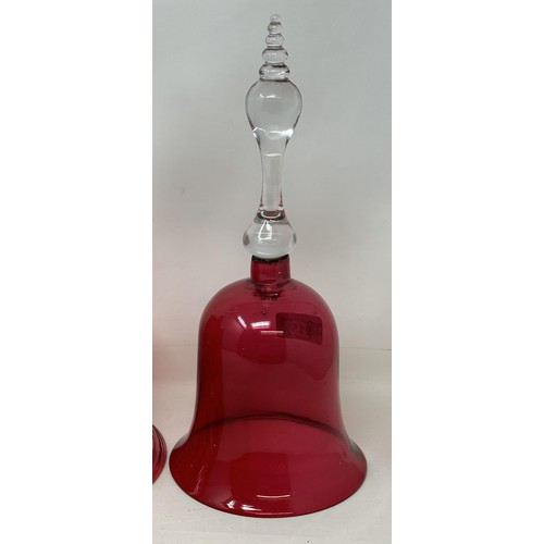 915 - A cranberry and clear glass bell, 34 cm high, and two others, all lacking ringers (3)