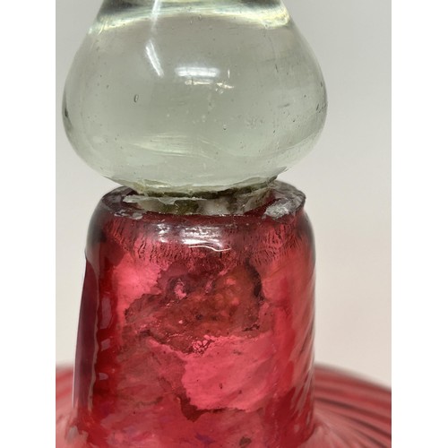 915 - A cranberry and clear glass bell, 34 cm high, and two others, all lacking ringers (3)