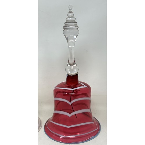 916 - A cranberry, opaque and clear glass bell, 28 cm, and another glass bell, lacking ringers