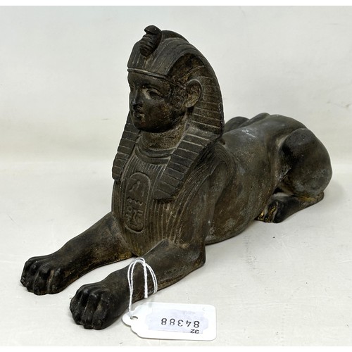 918 - An Egyptian style Sphinx, 25 cm wide, and a figure of a bull's head (2)