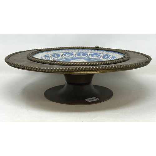 957 - A Wedgwood style Jasperware plate, inset into a brass mount with engraved decoration, 33 cm diameter