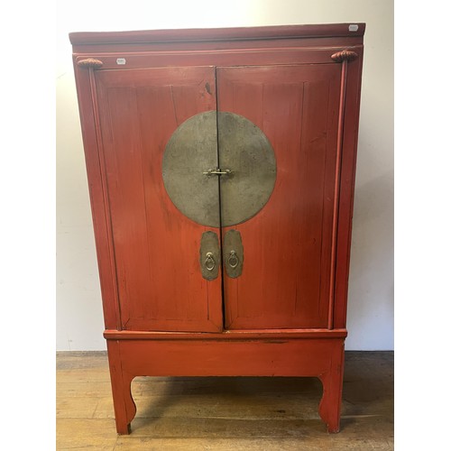 1158 - A Chinese red laquered cabinet, with metal mounts, 173 cm high x 108 cm wide