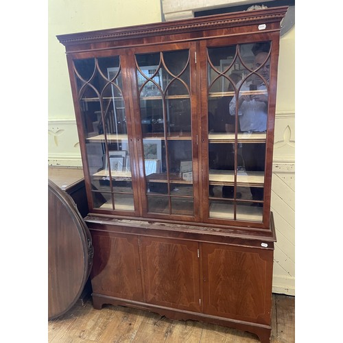 1110 - A mahogany bookcase cabinet, having three glazed doors, above a base with three cupboard doors, a di... 