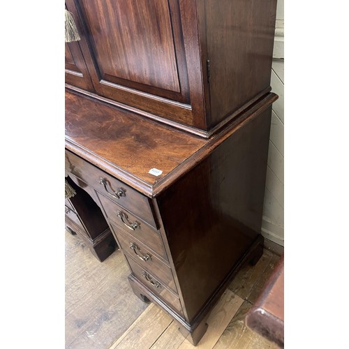 1172 - A 19th century mahogany kneehole desk, with a bookcase top having a pair of panel doors, opening to ... 