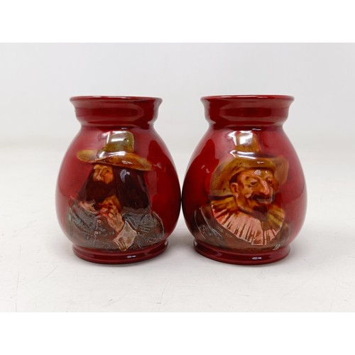 739 - A pair of Royal Doulton squat vases, by Charles Noke, decorated figures, 9 cm high (2)