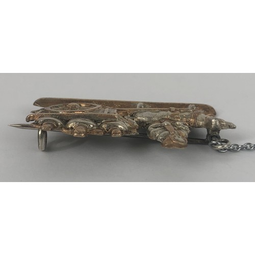 687 - A silver coloured metal brooch, in the form of a lady with a dog cart