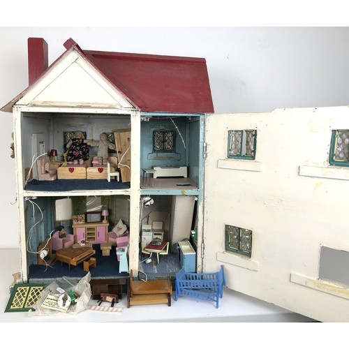 328 - A mid 20th century painted dolls house, with assorted furniture, 56 cm wide, a childs cot, toys, and... 