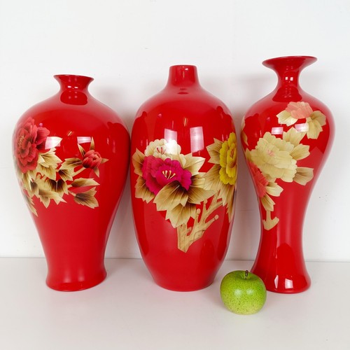 810 - A Japanese red ground vase, decorated flowers, 46 cm high, another similar, 48 cm high and another s... 