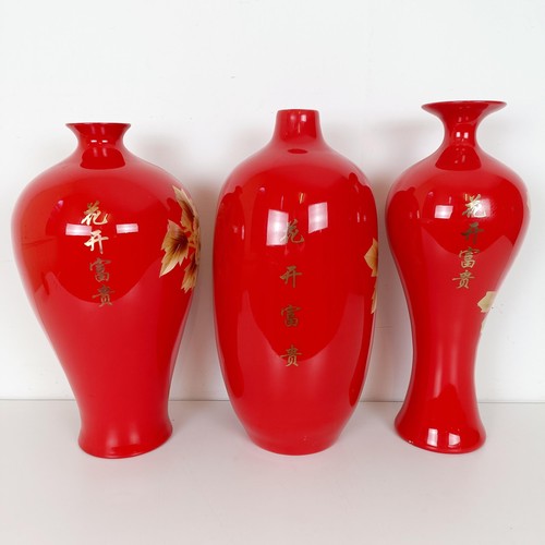 810 - A Japanese red ground vase, decorated flowers, 46 cm high, another similar, 48 cm high and another s... 