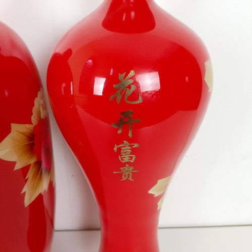 810 - A Japanese red ground vase, decorated flowers, 46 cm high, another similar, 48 cm high and another s... 