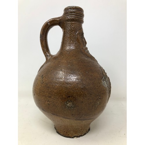 864 - A salt glazed Bellarmine jug, 22 cm high