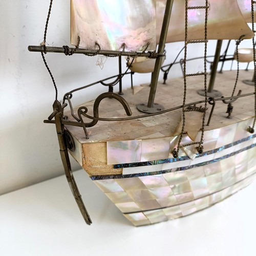 912 - A large mother of pearl veneered model of a ship, 60 cm high