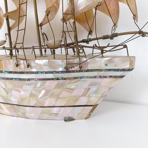 912 - A large mother of pearl veneered model of a ship, 60 cm high