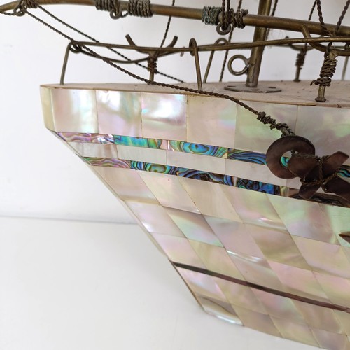 912 - A large mother of pearl veneered model of a ship, 60 cm high