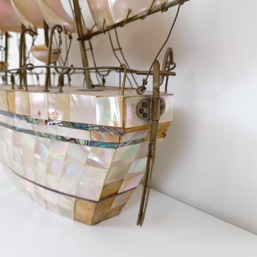 912 - A large mother of pearl veneered model of a ship, 60 cm high