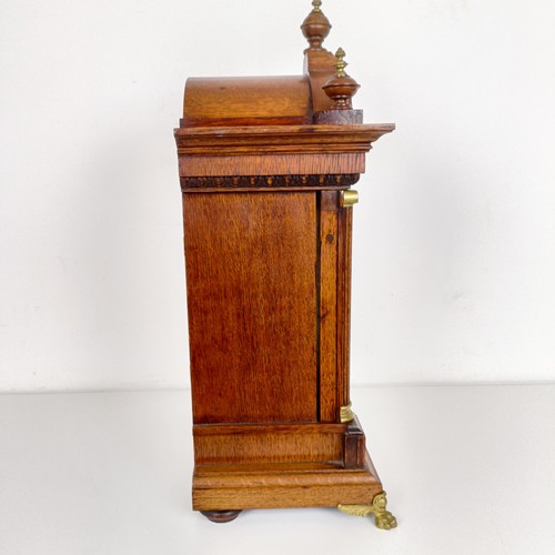 975 - A mantel clock, the brass dial with a silvered chapter ring, in an oak case, 56 cm high