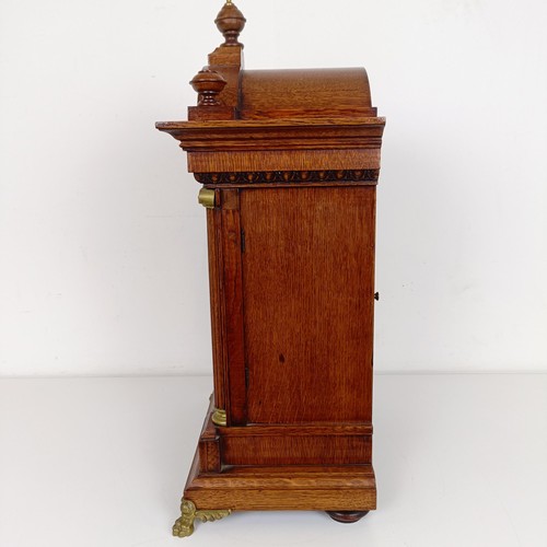 975 - A mantel clock, the brass dial with a silvered chapter ring, in an oak case, 56 cm high