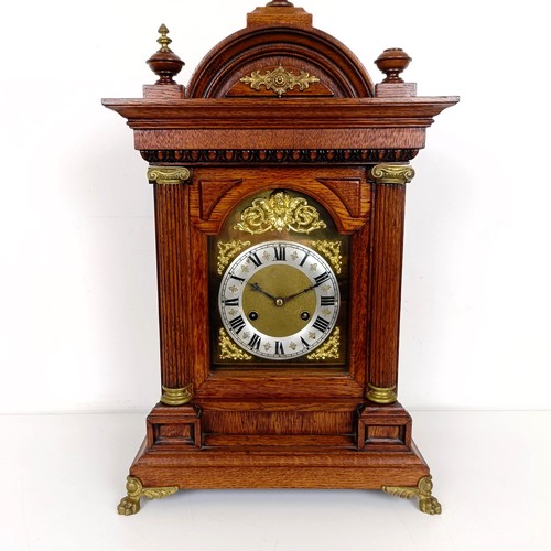 975 - A mantel clock, the brass dial with a silvered chapter ring, in an oak case, 56 cm high