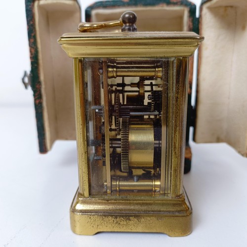 972 - A miniature carriage clock, with alarm, the enamel dial,  with Arabic numerals, in a brass and glass... 