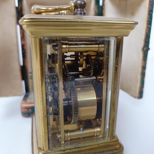 972 - A miniature carriage clock, with alarm, the enamel dial,  with Arabic numerals, in a brass and glass... 