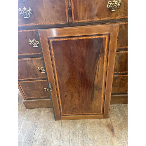 1061 - A mahogany linen press, the top with two cupboard doors, on a base with two short and three graduate... 