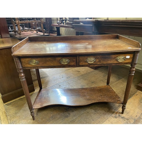 1007 - An early 19th century washstand, on tapering reeded legs joined by an undertier, 110 cm wide