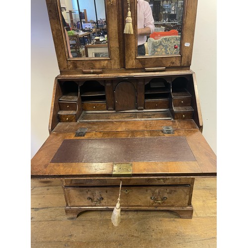 999 - A late 18th/early 19th century walnut bureau bookcase, the top having two mirrored doors above two c... 