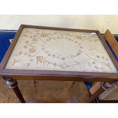 1088 - A Victorian walnut oval table, 125 cm wide, a side table, inset with with an embroidered panel, a co... 