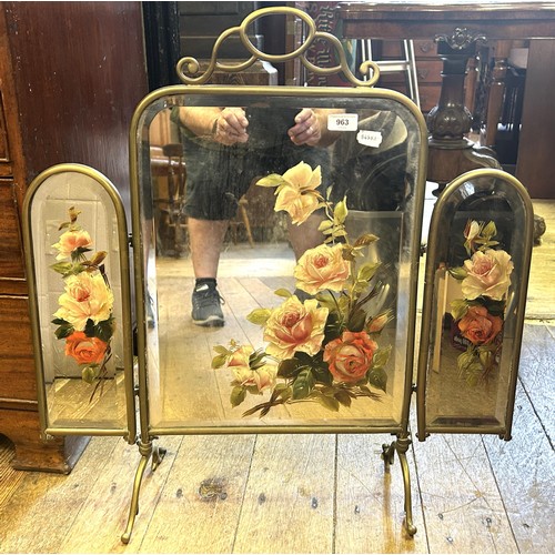 963 - An early 20th century painted mirror triptych fire screen, in a brass frame