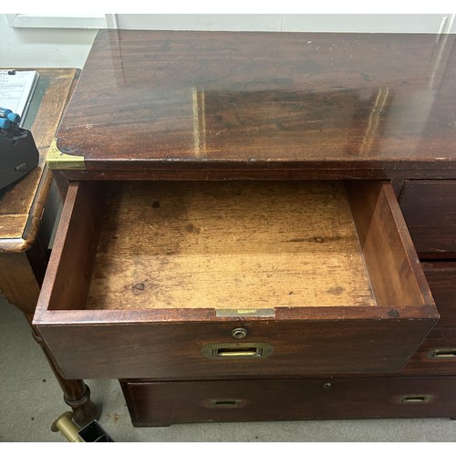 1034 - A mahogany and brass bound military chest, the top having two short and one long drawers, the base w... 