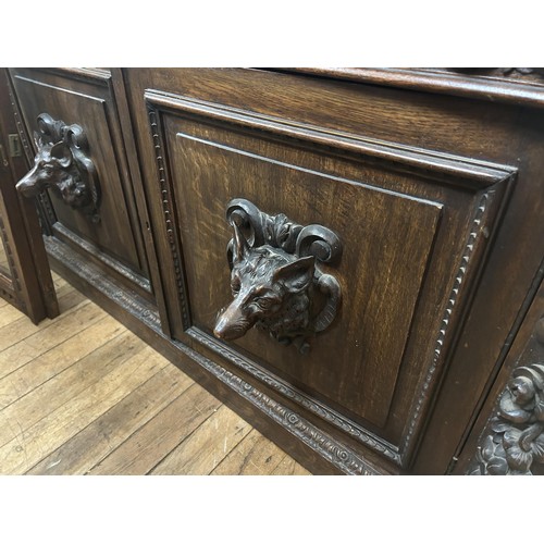 1080 - A late 19th century Anglo-Flemish carved oak bookcase, having a pair of glazed doors above a pair of... 