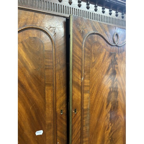 1062 - A 19th century inlaid mahogany linen press, the top having two cupboard doors, on a base with a secr... 