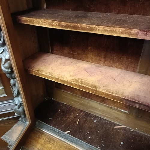 1080 - A late 19th century Anglo-Flemish carved oak bookcase, having a pair of glazed doors above a pair of... 