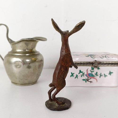 1061 - A bronze figure of a hare, 10 cm high, a silver plated cream jug, and an enamel box, decorated two f... 