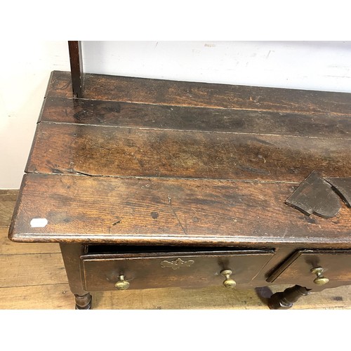 1104 - An oak dresser, having a two tier plate rack, on a base with three drawers, on turned legs, 178 cm w... 