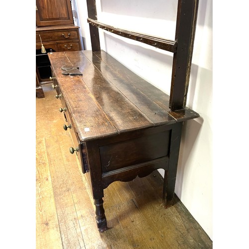 1104 - An oak dresser, having a two tier plate rack, on a base with three drawers, on turned legs, 178 cm w... 