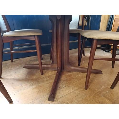 487 - A Danish hardwood extending dining table, 124 cm diameter, with two extra 49 cm leaves, and a set of... 