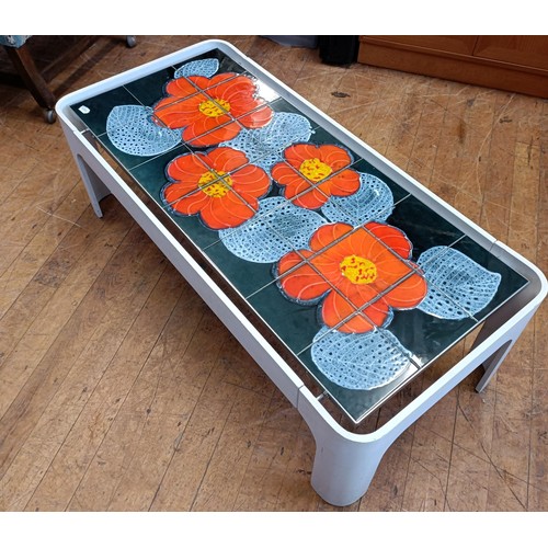 500 - A 1970s tiled top table, decorated flowers, 120 cm wide