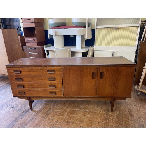 497 - A mid 20th century teak sideboard, having four drawers and two cupboard doors, 174 cm wide