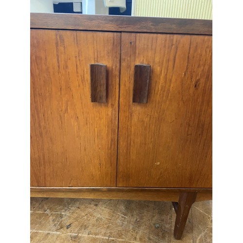 497 - A mid 20th century teak sideboard, having four drawers and two cupboard doors, 174 cm wide