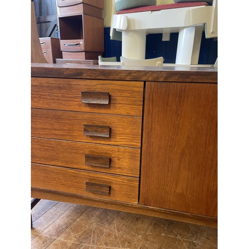 497 - A mid 20th century teak sideboard, having four drawers and two cupboard doors, 174 cm wide