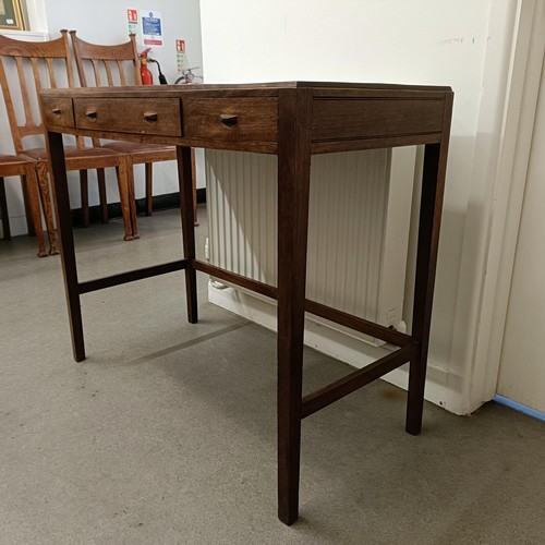 469 - A Cotswold School style walnut bow front table, having three freize drawers on tapering square legs ... 