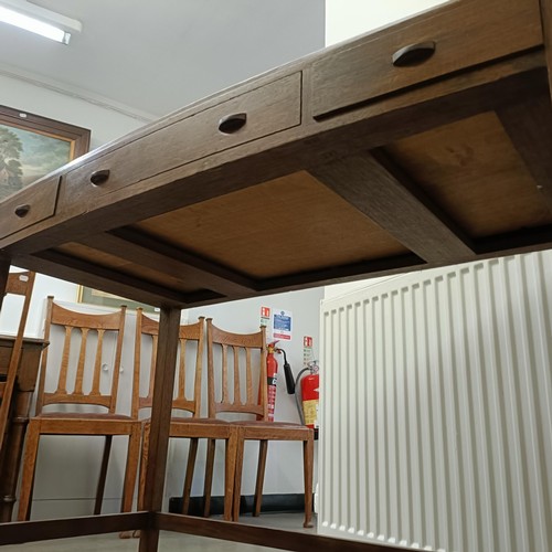 469 - A Cotswold School style walnut bow front table, having three freize drawers on tapering square legs ... 