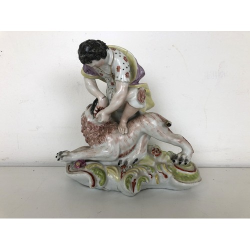 1259 - An 18th century porcelain group of a man wrestling a lion, 14 cm high