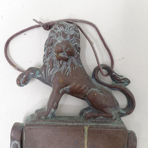 1292 - A bronze door knocker, with a lion finial, 25 cm high