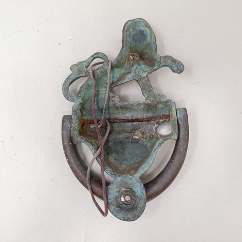 1292 - A bronze door knocker, with a lion finial, 25 cm high